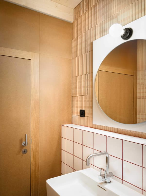 Architectural project - hygge, light fixture, bathroom, minimalist bathroom, compact bathroom, round mirror, cozy light, wall tiles, white sink, natural materials, sustainable materials, wood, timber, glass, warm tones, natural tones, eco design, beige, brown, functional design, compact space, contemporary design, Scandinavian style, clean lines, white, small space, earthy tones, cozy atmosphere, Nordic vibe, sleek design, efficient layout, warm lighting, modern bathroom, wood paneling, timber paneling, modern minimalist, Japandi, ceramic, tiled wall, ceramic tiles, red
