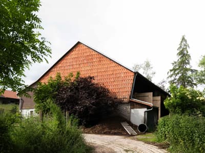 Architectural project - brick wall, brickwork, cottage vibe, garden, agricultural building, country house, red tiles, vintage feel, terracotta roof, vernacular style, farmhouse, lush landscape, natural materials, outdoor space, sustainable design, warm tones, simple structure, green, brown, eco friendly, rural architecture, natural palette, earthy tones, pitched roof, terracotta, rustic facade, red brick, greenery, natural environment, traditional style, rustic barn, gable roof, garden path, foliage, rural retreat, countryside setting, clay tiles, red