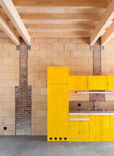Architectural project - loft kitchen, industrial loft, brick wall, exposed brick, lively atmosphere, design contrast, studio apartment, city apartment, bright yellow, rustic details, tile wall, vibrant kitchen, interior inspiration, wood, timber, raw materials, sustainable design, yellow, warm tones, contemporary style, grey, exposed beams, daylight, beige, concrete, geometric pattern, eco friendly, natural textures, minimalist design, creative space, light filled, timber ceiling, brick, minimalist aesthetic, bright interior, modern kitchen, compact living, wood ceiling, concrete floor, open shelving, ceramic, spacious feel, home renovation, urban living, urban vibe, pop of color
