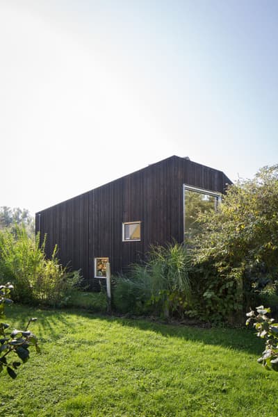Architectural project - wood, timber, outdoor space, natural light, sustainable design, natural tones, contemporary style, sustainable architecture, green, brown, daylight optimization, minimalist design, black, eco materials, low carbon, biophilic design, passive house, scenic view, landscape integration, clean lines, timber cladding, eco friendly home, modern architecture, countryside home, large window, compact design, woodland setting, residential design, natural environment, garden view, secluded retreat, wooden facade, green lawn, modern cabin, black timber house, simple shape, geometric, small windows, private dwelling, dark tones, efficient design