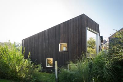 Architectural project - natural materials, sustainable materials, wood, timber, natural light, rustic touch, sustainable design, glass, natural tones, daylight, wood facade, low carbon design, eco friendly, Scandinavian influence, minimalist design, eco home, passive house, contemporary home, landscape integration, clean lines, large windows, timber cladding, wood cladding, harmonious design, countryside home, energy efficient, environmental design, rural setting, garden view, nature integration, timber exterior, sustainable facade, energy saving, warm exterior, modern exterior, compact home, dark tones, dark wood, small footprint, cubic shape, rectangular form, picture windows, Nordic architecture, cabin vibe, exterior cladding, blackened wood, charred timber, earthy landscape, simple exterior