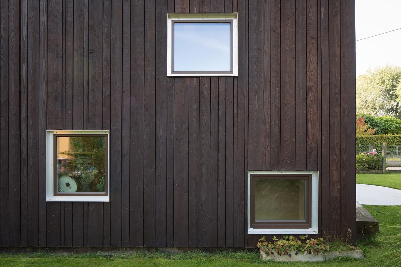 Architectural project - natural materials, architectural detail, wood, timber, natural light, glass, warm tones, daylight, wood facade, timber facade, natural wood, exterior wall, simple design, modern simplicity, Scandinavian style, minimalist design, sustainable building, warm wood, passive house, contemporary home, eco friendly home, Nordic style, energy efficient, earthy tones, nature-inspired, greenery, garden view, residential architecture, cozy exterior, private residence, wooden cladding, outdoor design, textured facade, earthy textures, vertical cladding, modern exterior, dark tones, dark wood, residential facade, square windows, framed windows, eco facade, compact window, refined architecture, geometry in design, outdoor greenery, plant box, inviting facade