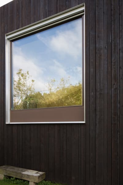 Architectural project - wood, timber, grey, steel, natural light, sustainable design, glass, exterior wall, functional design, eco friendly, natural setting, rustic charm, minimalist architecture, contemporary design, Scandinavian style, black, outdoor seating, passive house, nature view, landscape integration, clean lines, timber cladding, wood cladding, Nordic design, large window, energy efficient, nature-inspired, reflective surface, cozy exterior, wooden facade, minimalist exterior, wooden structure, simple lines, modern exterior, window frame, picture window, small home, dark facade, black wood, outdoor relaxation, charred wood, charred facade, reflective glass, natural reflection, outdoor bench, compact dwelling, low carbon architecture, geometric form, architectural cut, dark wood