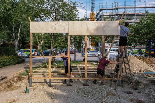Architectural project - wooden planks, construction tools, collaborative work, wood, timber, scaffolding, timber frame, construction site, urban construction, daylight, site work, outdoor construction, teamwork, project planning, natural setting, outdoor, sustainable building, eco construction, skeletal structure, workspace, building foundation, timber assembly, site preparation, construction progress, wood frame, sunlit, open air, architectural process, community project, building project, natural surroundings, site activity