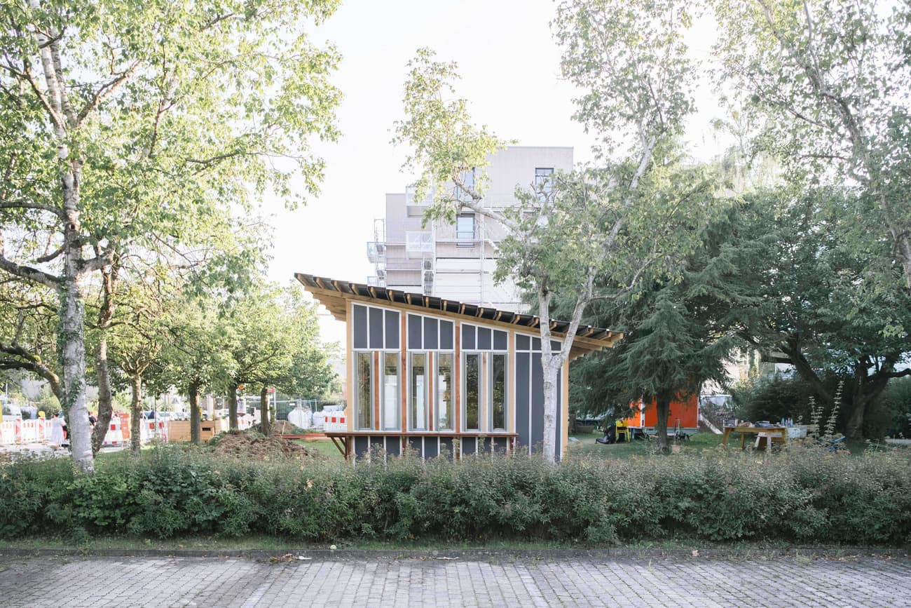 Architectural project - urban greenery, garden pavilion, gathering place, light-filled interior, angled roof, community area, natural materials, eco-friendly design, wood, timber, steel, outdoor space, natural light, passive design, glass, warm tones, green building, contemporary style, urban park, sustainable architecture, grey, green, neutral tones, daylight, landscape architecture, brown, timber facade, light wood, modern design, public space, park setting, lightweight structure, biophilic design, timber cladding, sloped roof, canopy roof, environmental design, nature integration, small pavilion, eco architecture, minimalist aesthetic, wooden cladding, open space, low carbon building, glass facade, eco conscious design