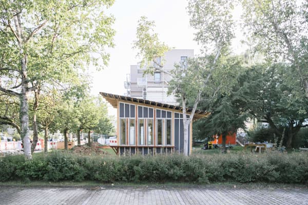 Architectural project - urban greenery, garden pavilion, gathering place, light-filled interior, angled roof, community area, natural materials, eco-friendly design, wood, timber, steel, outdoor space, natural light, passive design, glass, warm tones, green building, contemporary style, urban park, sustainable architecture, grey, green, neutral tones, daylight, landscape architecture, brown, timber facade, light wood, modern design, public space, park setting, lightweight structure, biophilic design, timber cladding, sloped roof, canopy roof, environmental design, nature integration, small pavilion, eco architecture, minimalist aesthetic, wooden cladding, open space, low carbon building, glass facade, eco conscious design