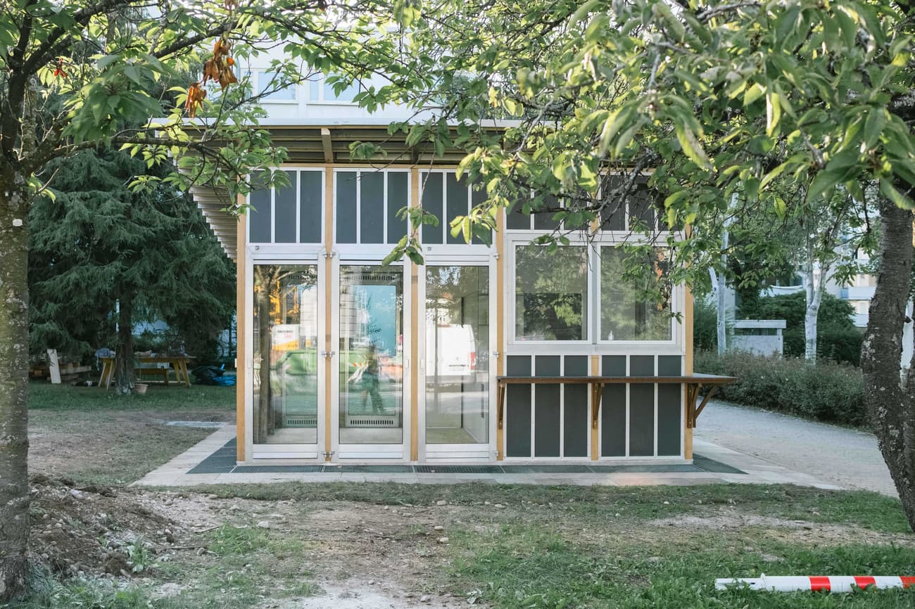 Architectural project - small house, prefab structure, garden house, green spaces, garden setting, minimal design, natural materials, wood, timber, timber frame, natural light, outdoor living, glass, natural tones, eco design, green building, simple structure, grey, green, neutral tones, daylight, beige, eco friendly, natural setting, retreat space, minimalist design, low carbon, sustainable home, large windows, indoor outdoor, timber cladding, wood cladding, white, modular home, wood frame, compact design, small structure, nature integration, cottage style, glass facade, modern cabin, small footprint, tiny home