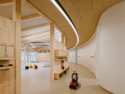 Architectural project - creative design, indoor play, educational facility, curved architecture, natural materials, wood, timber, playful design, natural light, sustainable design, warm tones, community space, neutral tones, daylight, beige, multifunctional space, eco friendly, natural textures, Scandinavian style, playful environment, social hub, light tones, Nordic style, wooden interior, beige tones, timber ceiling, timber interior, open layout, open plan, inviting space, cozy atmosphere, warm vibe, bright interior, wood ceiling, simple lines, learning center, family-friendly