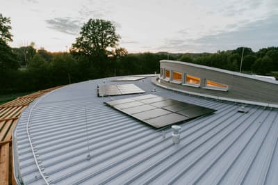 Architectural project - metal cladding, silver, futuristic design, open sky, solar panels, roof terrace, grey tones, steel, metal, outdoor space, sustainable design, green building, grey, roof design, daylight optimization, contemporary design, minimalist design, black, exterior, passive house, natural ventilation, metal roof, modern architecture, landscape view, energy efficient, environmental design, rural setting, environmental architecture, nature integration, eco architecture, energy saving, curved roof, renewable energy, architectural innovation, modern materials