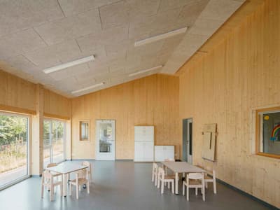 Architectural project - flexible space, off-white, spacious room, welcoming environment, modular furniture, acoustic panels, simple interior, minimal design, cozy interior, warm interior, indoor space, eco-friendly design, sustainable materials, wood, timber, natural light, inviting atmosphere, green building, community space, neutral tones, daylight, beige, light wood, natural wood, honey wood, Scandinavian style, light tones, timber walls, window view, wood walls, open layout, child friendly, bright space, nordic influence, educational space, soft colors, informal seating