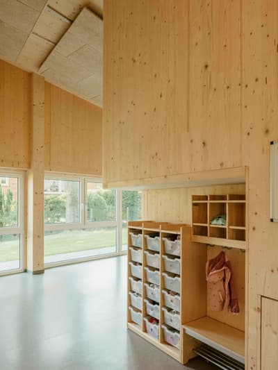 Architectural project - beige floor, calm vibe, educational facility, classroom, warm interior, sustainable materials, natural light, warm tones, eco design, neutral tones, daylight, multi-use space, plywood, light wood, natural wood, engineered wood, functional design, eco friendly, simple design, honey wood, minimalist style, community center, timber walls, passive house, large windows, timber cladding, wood cladding, Nordic design, timber interior, inviting space, child friendly, cozy atmosphere, green design, Scandinavian design, bright interior, wood ceiling, open space, educational space, learning space, modern school, indoor, built-in storage, school interior, wood interior