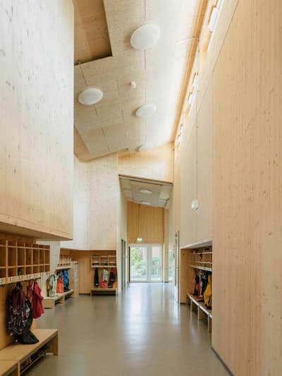 Architectural project - exposed timber, open ceiling, bright hallway, indoor space, wood, timber, natural light, sustainable design, warm tones, neutral tones, daylight, gathering space, beige, light wood, natural wood, functional design, eco friendly, modern design, honey wood, contemporary design, Scandinavian style, minimalist design, community center, timber walls, low carbon, passive house, clean lines, Nordic style, timber ceiling, inviting space, wood texture, educational space, educational building, public building, hallway, modern interior, organized space, skylight, high ceiling, double height, wood interior