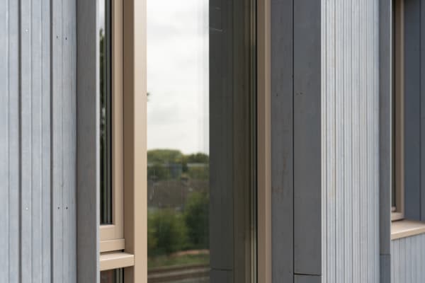 Architectural project - facade, modern building, vertical lines, glazed facade, metal cladding, light grey, architectural detail, grey tones, natural light, passive design, eco design, grey, beige, exterior design, building facade, minimalist facade, light wood, daylight optimization, exterior detail, contemporary design, industrial touch, neutral palette, minimalist design, light tones, modern facade, corrugated metal, clean lines, large windows, energy efficient design, modern architecture, outdoor view, residential building, sustainable facade, textured facade, sleek design, urban architecture, modern exterior, vertical panels, window detail, building envelope, exterior cladding, urban living