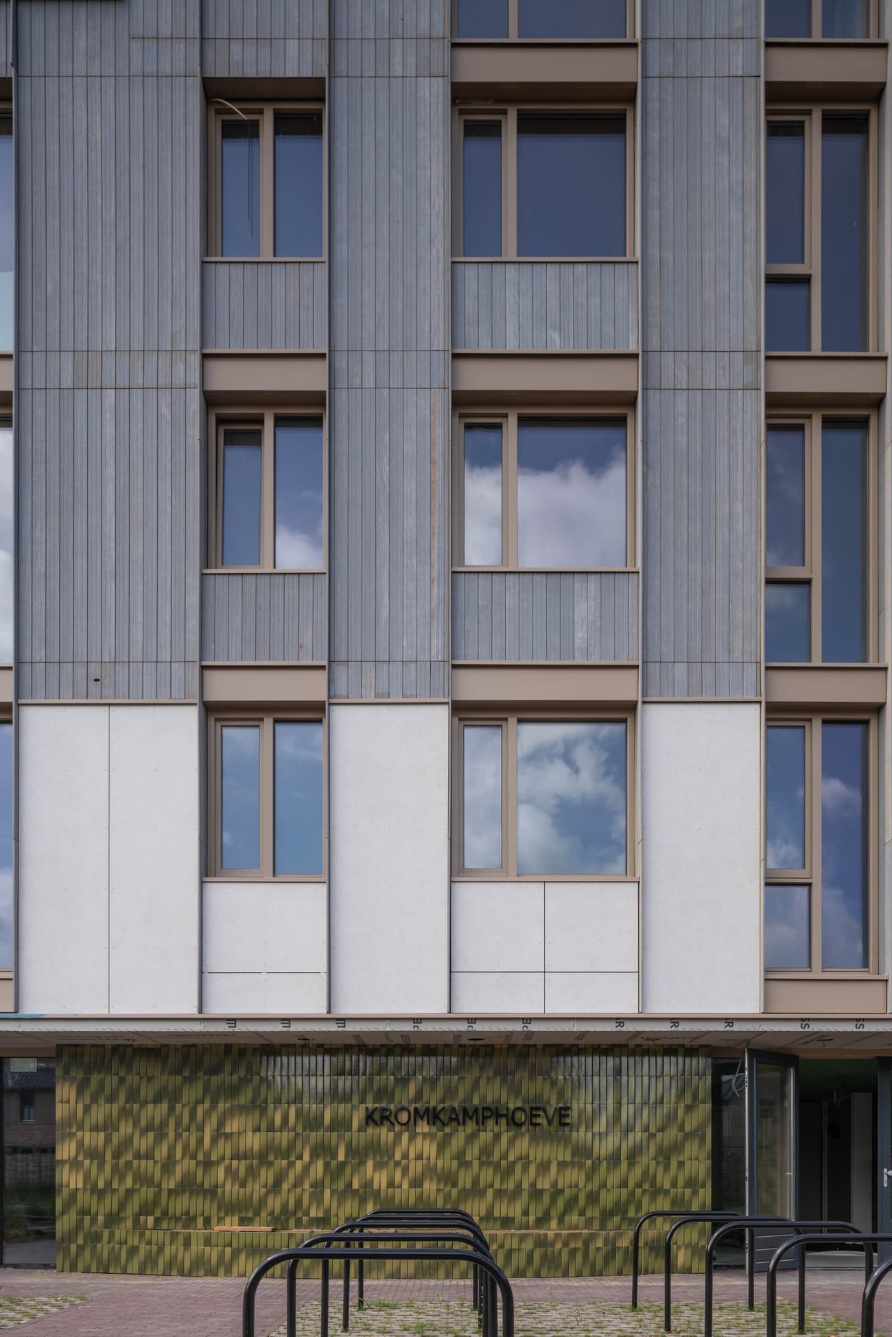 Architectural project - apartment facade, linear design, urban dwelling, metal cladding, grey facade, urban renewal, green facade, sleek look, muted colors, exterior architecture, housing complex, pastel tones, city living, cityscape, passive design, recycled materials, glass, modular design, eco design, sustainable architecture, grey, green, neutral tones, modern construction, geometric design, textured surface, energy efficient, eco-friendly building, residential building, textured facade, contemporary facade, urban architecture, vertical panels, mixed materials, eco facade, urban housing