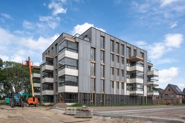 Architectural project - multi-story building, angular design, cubic form, metal accents, circular economy, community living, facade cladding, steel frames, minimal design, modular construction, outdoor area, grey, construction site, urban development, engineered wood, glass panels, flat roof, contemporary design, light tones, sustainable building, machinery, passive house, natural ventilation, modern facade, clean lines, large windows, timber cladding, white, modern architecture, concrete base, eco-friendly structure, exterior view, residential building, floor to ceiling glass, vertical panels, energy efficiency, urban housing