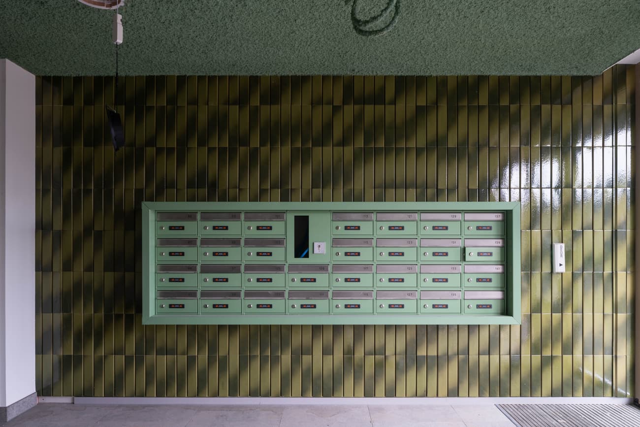 Architectural project - beige floor, dark green, eye-catching design, green tiles, communal area, statement wall, glossy tiles, textured tiles, architectural detail, playful design, artistic touch, sustainable design, eco design, contemporary style, neutral tones, functional space, geometric pattern, minimalist design, public space, vibrant colors, inviting entrance, residential building, sleek design, interior, modern style, interior space, simple lines, practical design, tiled wall, ceramic tiles, pop of color, modern entry