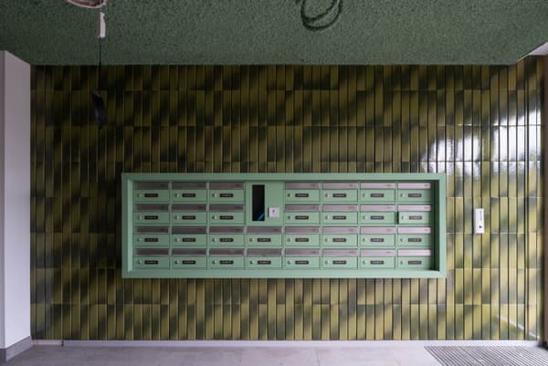 Architectural project - beige floor, dark green, eye-catching design, green tiles, communal area, statement wall, glossy tiles, textured tiles, architectural detail, playful design, artistic touch, sustainable design, eco design, contemporary style, neutral tones, functional space, geometric pattern, minimalist design, public space, vibrant colors, inviting entrance, residential building, sleek design, interior, modern style, interior space, simple lines, practical design, tiled wall, ceramic tiles, pop of color, modern entry