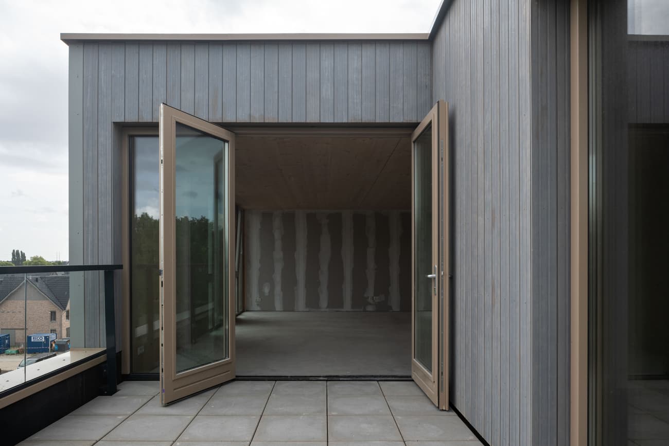 Architectural project - urban dwelling, light grey, muted colors, balcony access, open doors, city view, natural materials, wood, timber, grey tones, outdoor space, passive design, sustainable design, glass, contemporary style, grey, exterior design, light wood, functional design, flat roof, minimalist vibe, minimalist architecture, neutral palette, glass doors, eco home, modern facade, clean lines, timber cladding, architectural details, simple forms, wooden facade, residential building, modern home, sleek design, vertical cladding, energy efficiency, terrace access, urban facade, urban living