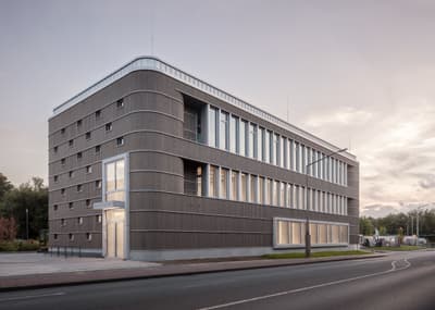 Architectural project - linear design, curved corners, metal facade, aluminum cladding, commercial space, streamlined design, horizontal lines, exterior lighting, simple geometry, built environment, office building, ribbon windows, muted facade, ribbed surface, civic architecture, modular layout, modern offices, corporate building, clean facade, structured facade, grey tones, urban setting, cityscape, eco design, urban landscape, grey, urban environment, urban planning, functional design, daylight optimization, facade detail, minimalist aesthetics, minimalist design, neutral colors, sustainable building, modern facade, clean lines, white, energy efficient, glass windows, sleek design, urban architecture, facade texture, public building, facade rhythm, street view, contemporary building