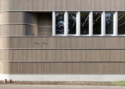 Architectural project - office building, window strip, cladding detail, rhythm facade, window arrangement, sunlight pattern, architectural design, sustainable materials, wood, timber, sustainable design, warm tones, eco design, neutral tones, daylight, city building, beige, wood facade, timber facade, minimalist facade, light wood, natural wood, exterior wall, sunlight, contemporary design, green architecture, passive house, modern facade, large windows, energy efficient, exterior texture, wood texture, earthy tones, sleek design, curved wall, design detail, vertical cladding, public building, urban facade