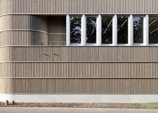 Architectural project - office building, window strip, cladding detail, rhythm facade, window arrangement, sunlight pattern, architectural design, sustainable materials, wood, timber, sustainable design, warm tones, eco design, neutral tones, daylight, city building, beige, wood facade, timber facade, minimalist facade, light wood, natural wood, exterior wall, sunlight, contemporary design, green architecture, passive house, modern facade, large windows, energy efficient, exterior texture, wood texture, earthy tones, sleek design, curved wall, design detail, vertical cladding, public building, urban facade
