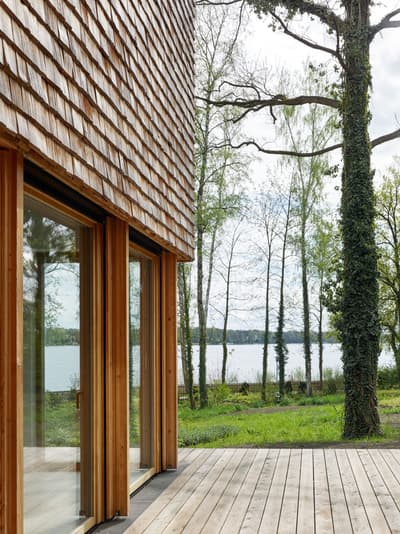 Architectural project - natural materials, wood, timber, grey, natural light, passive design, glass, warm tones, daylight, beige, brown, wood facade, timber facade, eco friendly, natural setting, simple design, Scandinavian style, serene space, natural palette, biophilic design, eco home, indoor outdoor, timber cladding, timber house, Nordic style, large window, landscape view, energy efficient, rustic style, open plan, inviting space, earthy tones, cozy atmosphere, nature retreat, forest view, timber deck, peaceful vibe, sustainable cabin, nature integration, green design, rustic retreat, lakeside view, wooden house, shingle, wooden cladding, shingle siding, shingle facade, wood siding, waterfront view, lake cabin, eco retreat, outdoor deck, wooden deck, glass door, floor to ceiling glass, wooden textures, rustic textures