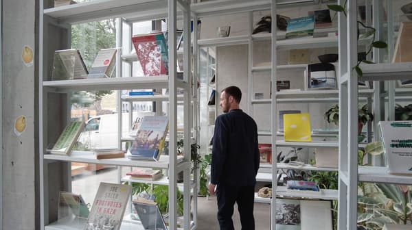 Architectural project - urban greenery, public access, artistic vibe, white shelves, cultural venue, modern shelving, library, bookshelves, calming atmosphere, steel, natural light, sustainable design, glass, grey, green, functional space, daylight, concrete, contemporary design, minimalist design, public space, steel frame, clean lines, large windows, white, modern architecture, inviting interior, open layout, environmental design, eco friendly space, spacious interior, reading nook, study area, sleek design, minimal decor, educational space, learning environment, glass facade, open shelving, indoor plants, street view