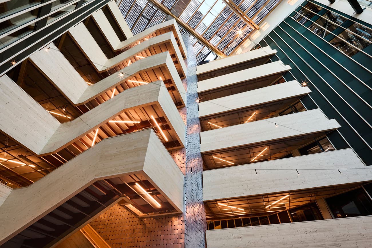 Architectural project - vertical windows, open ceiling, angular design, metal detailing, glass elements, raw aesthetics, sleek interior, lobby, multipurpose space, high rise, office building, geometric patterns, natural materials, sustainable design, warm tones, exposed structure, grey, beige, brown, light wood, engineered wood, daylight optimization, eco friendly, wooden beams, contemporary design, minimalist design, black, urban design, industrial chic, CLT, cross laminated timber, natural ventilation, modern facade, large windows, timber cladding, modern architecture, eco architecture, wooden facade, public building, warm lighting, atrium, structural rhythm, urban vibe