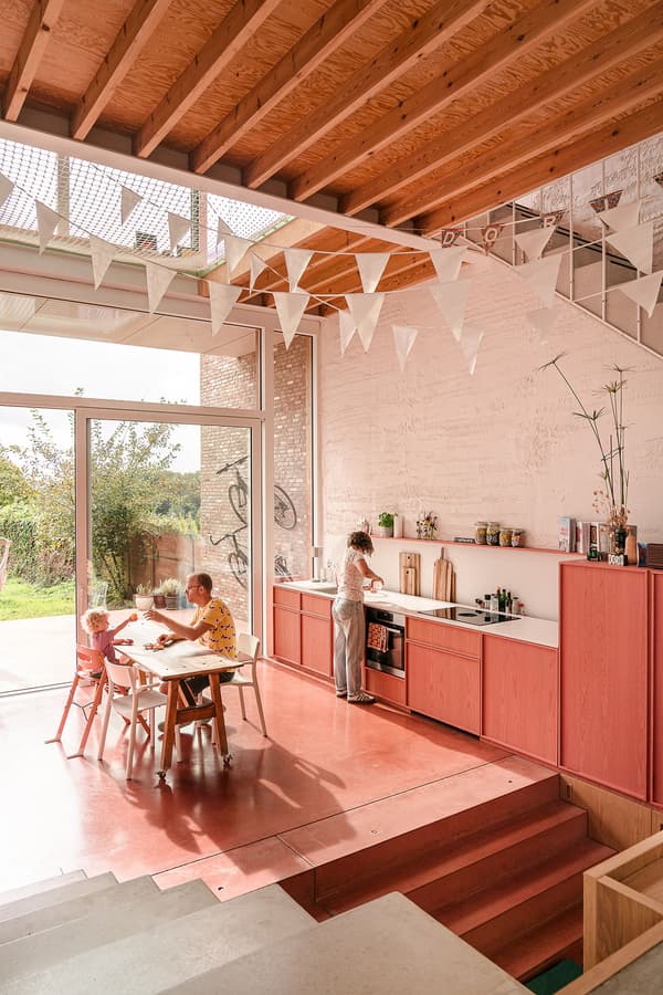 Architectural project - concrete stairs, red floor, rustic touches, family dining, concrete steps, family table, vibrant kitchen, open kitchen, pink, wood, timber, natural light, sustainable design, warm tones, neutral tones, beige, concrete, light wood, modern design, honey wood, natural textures, Scandinavian style, glass doors, eco home, indoor outdoor, white, cozy vibe, inviting home, plaster, open shelves, family kitchen, comfortable home, casual living, open layout, open plan, dining area, dining table, white chairs, garden view, warm vibe, sliding doors, modern style, playful space, kid friendly, renovation, minimalist shelves, colorful space, playful decor, red, remodel