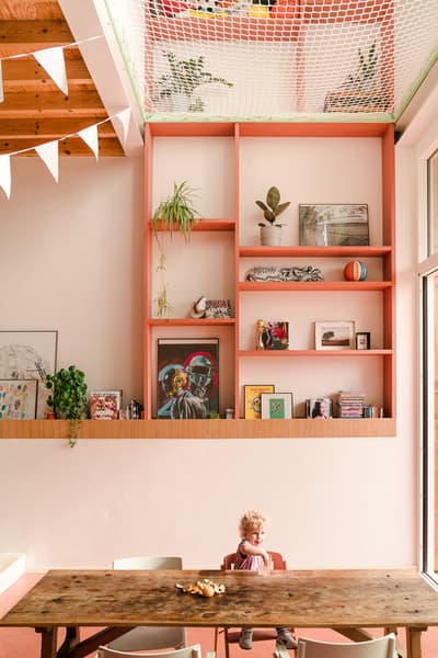 Architectural project - vibrant design, artistic vibe, playful interior, potted plants, homey vibe, bohemian touch, colorful decor, pastel pink, pink, wood, timber, relaxed vibe, natural light, eclectic style, warm tones, exposed beams, daylight, light wood, natural wood, casual seating, gallery wall, beige tones, cozy nook, timber ceiling, wooden table, inviting space, warm atmosphere, greenery, bright interior, nordic influence, family room, open shelving, spacious feel, Scandinavian inspiration, indoor plants, high ceiling