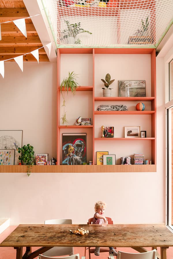 Architectural project - vibrant design, artistic vibe, playful interior, potted plants, homey vibe, bohemian touch, colorful decor, pastel pink, pink, wood, timber, relaxed vibe, natural light, eclectic style, warm tones, exposed beams, daylight, light wood, natural wood, casual seating, gallery wall, beige tones, cozy nook, timber ceiling, wooden table, inviting space, warm atmosphere, greenery, bright interior, nordic influence, family room, open shelving, spacious feel, Scandinavian inspiration, indoor plants, high ceiling