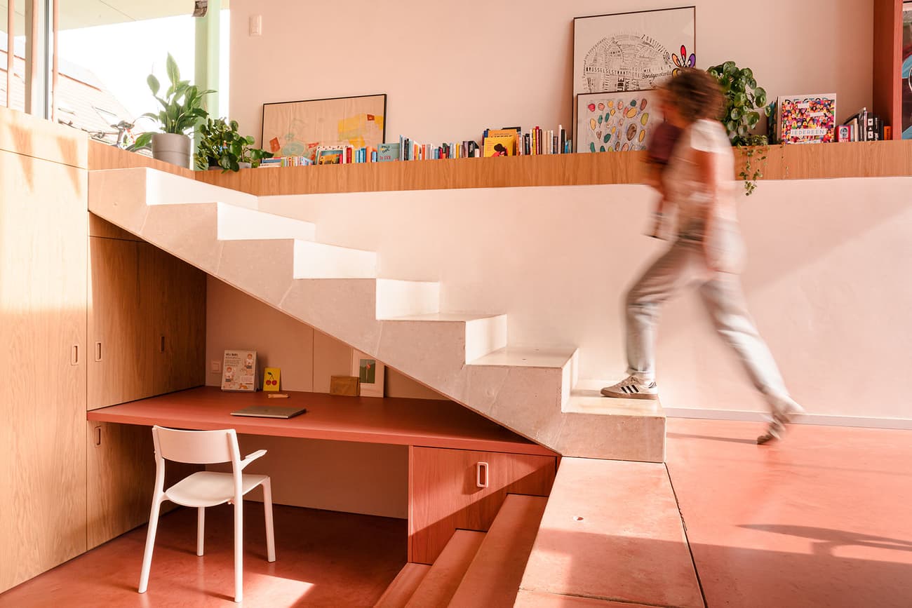 Architectural project - modern staircase, efficient use, Nordic touch, white steps, pink floor, minimal design, warm interior, wood elements, pink, wood, timber, natural light, warm tones, daylight, beige, light wood, functional design, calming space, contemporary interior, relaxed atmosphere, vibrant colors, Scandinavian vibe, creative space, workspace, white, timber accents, plaster, compact design, earthy tones, playful vibe, residential design, cozy corner, reading nook, home office, minimalist space, family home, compact living, plaster walls, open shelving, smooth finish, terracotta floor, indoor plants, staircase, bright home