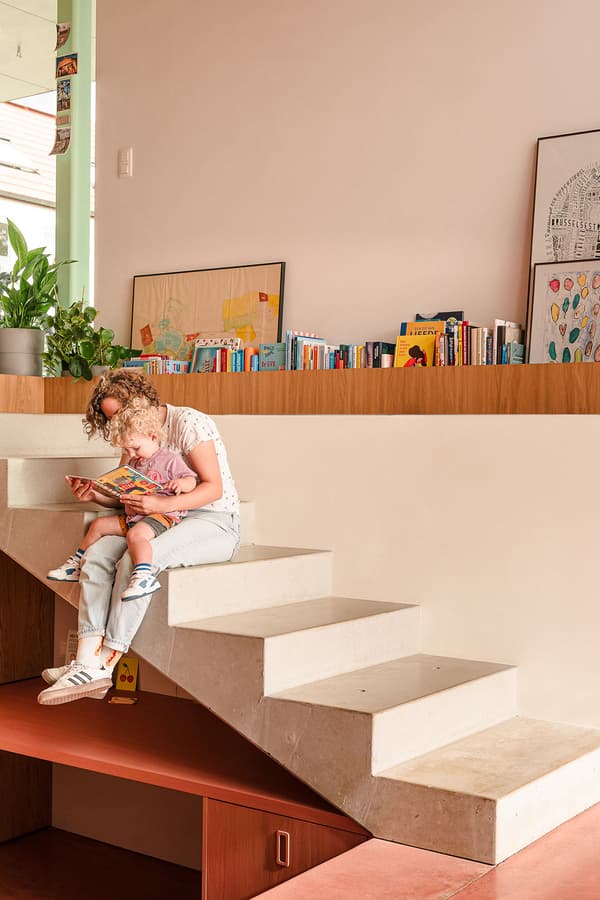 Architectural project - cozy living, playful interior, concrete steps, art display, compact area, pastel pink, architectural detail, pastel tones, wood, relaxed vibe, natural light, sustainable design, eco design, beige, concrete, multifunctional space, neutral palette, white, inviting home, cozy nook, warm atmosphere, terracotta, residential design, beige wall, home library, bright space, simple decor, home design, educational space, learning space, modern interior, open shelving, indoor plant, reading corner, family area, inviting corner