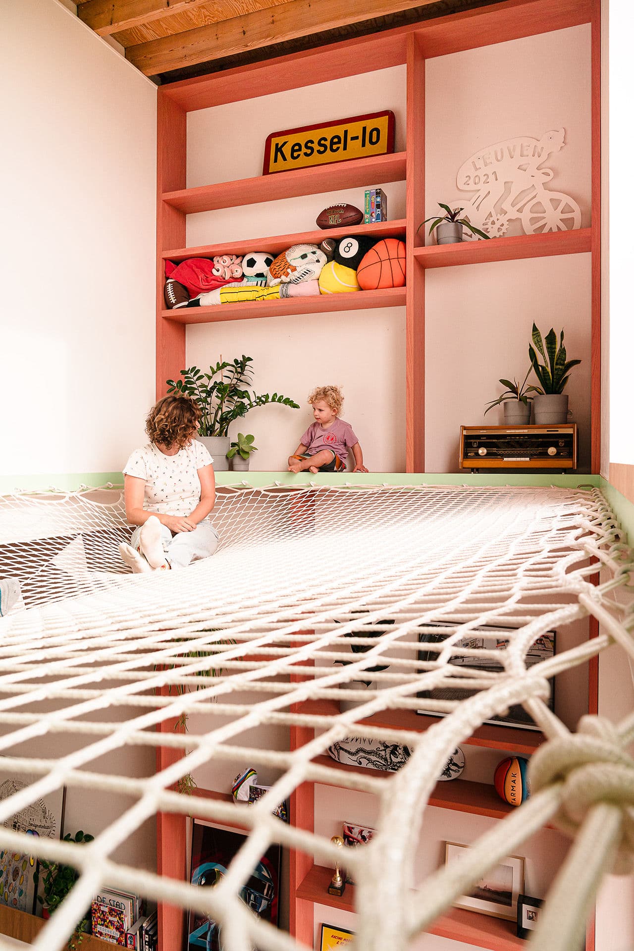 Architectural project - plants, indoor play, playful area, kids room, colorful design, pastel pink, natural materials, pastel tones, timber, warm tones, exposed beams, wooden ceiling, beige, light wood, Scandinavian style, vibrant colors, creative space, Nordic design, inviting home, timber ceiling, open shelves, family space, playful vibe, cozy atmosphere, relaxed setting, cozy corner, greenery, bright space, playroom, shelving, indoor plants, family-friendly