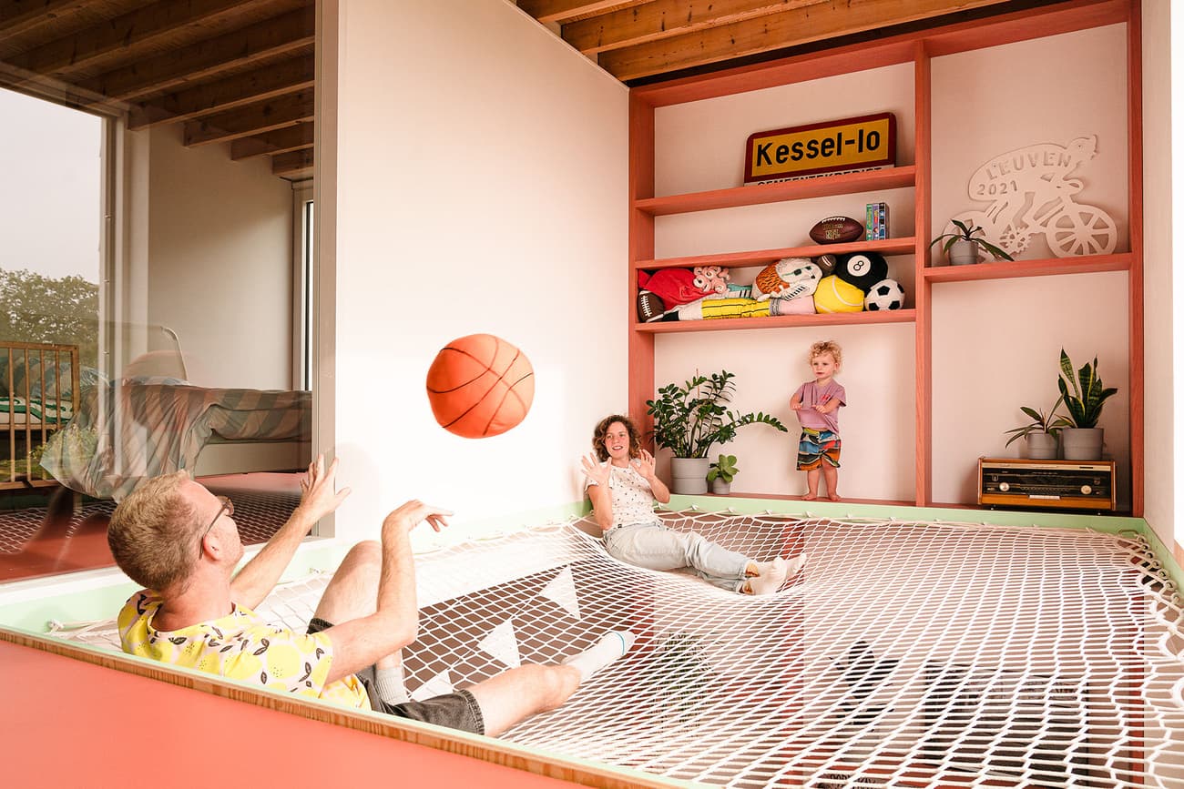 Architectural project - indoor greenery, red accents, creative design, family interaction, kids room, spacious room, relaxation space, wood, timber, playful design, pastel colors, warm tones, green, exposed beams, recreational area, beige, natural wood, timber beams, leisure space, eco materials, casual seating, light tones, inviting home, open layout, family gathering, child friendly, cozy atmosphere, bright interior, contemporary vibe, playful space, open shelving, red