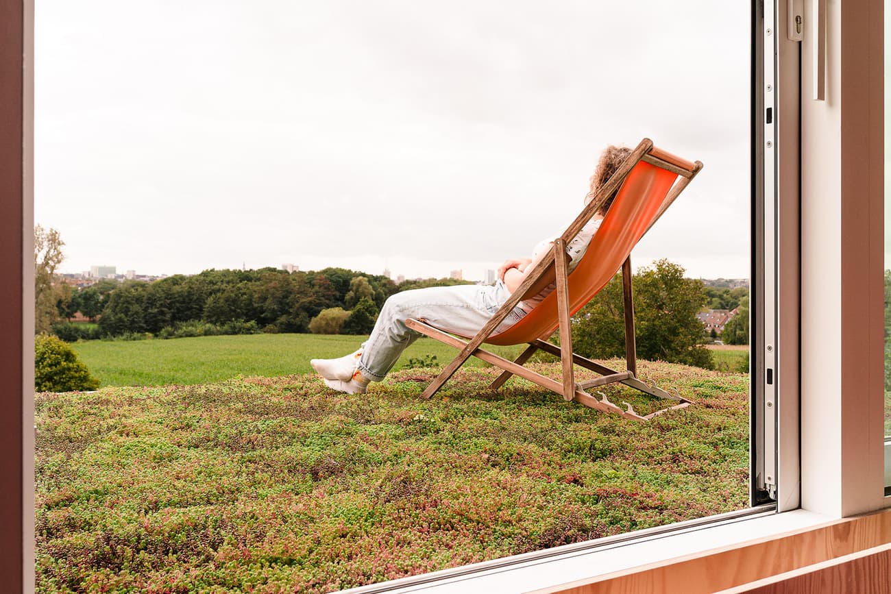 Architectural project - tranquil scene, peaceful environment, city escape, rooftop garden, indoor green, balcony view, wood details, folding chair, eco roof, timber, passive design, sustainable design, green, neutral tones, landscape architecture, beige, eco friendly, natural textures, relaxation, serene space, outdoor seating, orange, natural landscape, green architecture, earth tones, biophilic design, scenic view, indoor outdoor, white, large window, outdoor view, natural colors, panoramic view, environmental design, nature retreat, fresh air, seamless transition, urban nature, open window, green roof, living roof, picture window