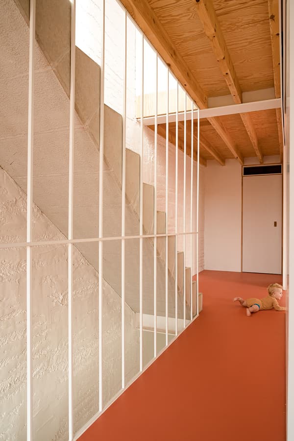 Architectural project - modern staircase, textured surfaces, open ceiling, red floor, white railing, japandi vibe, open beams, bright hallway, warm floor, indoor space, architectural detail, wood, natural light, warm tones, contemporary style, neutral tones, daylight, wooden ceiling, structural design, light wood, functional design, Scandinavian influence, wood beams, natural textures, sleek lines, minimalist style, minimalist design, eco-friendly materials, sustainable home, contemporary home, white, inviting home, Nordic style, textured wall, plaster wall, plaster, timber ceiling, airy space, casual living, warm atmosphere, terracotta, residential design, cozy corner, family home, simple lines, practical design, modern interior, terracotta floor, stairwell, exposed ceiling