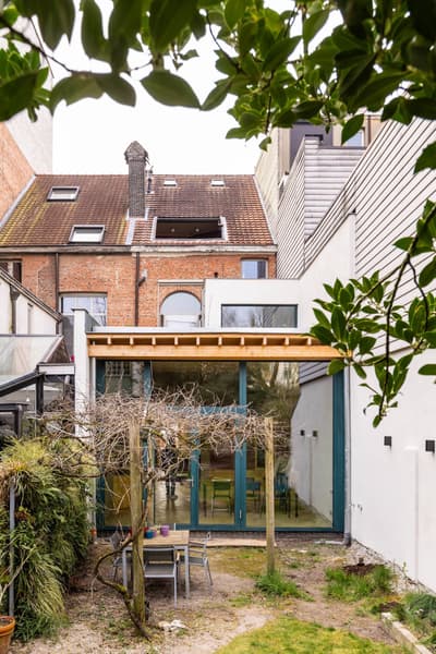 Architectural project - terrace, city garden, modern addition, contemporary extension, home extension, brick house, patio, row house, cozy garden, backyard design, urban backyard, brown roof, minimal design, wood, timber, natural light, glass, warm tones, eco design, contemporary style, green, neutral tones, exposed beams, daylight, brown, concrete, light wood, wooden beams, honey wood, natural textures, outdoor seating, sustainable home, timber roof, clean lines, white walls, indoor outdoor, white, open plan, glass walls, inviting space, alfresco dining, brick, relaxing space, brick facade, garden view, residential architecture, green design, family home, sliding doors, modern style, glass facade, urban home, mixed materials, urban retreat, city dwelling
