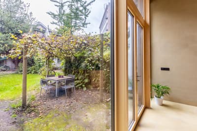 Architectural project - terrace, city garden, minimalist garden, potted plant, modern extension, small garden, patio doors, home addition, natural light, outdoor living, warm tones, eco design, outdoor area, functional space, daylight, compact space, natural setting, natural textures, relaxation spot, biophilic design, indoor outdoor, inviting home, open plan, earthy tones, garden dining, casual dining, nature connection, garden retreat, cozy corner, exterior view, garden view, calm atmosphere, wooden frames, fresh air, seamless transition, modern style, green space, urban garden, sustainable living, glass wall, simple furniture, backyard seating, light beige