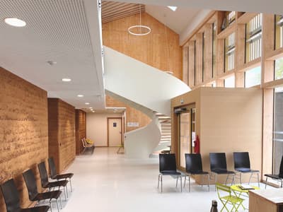 Architectural project - raw finishes, modern staircase, public venue, gathering place, rammed earth walls, green construction, social area, meeting space, warm interior, natural materials, sustainable materials, wood, timber, natural light, sustainable design, eco design, community space, innovative design, contemporary style, daylight, wooden ceiling, beige, brown, architectural elements, structural design, light wood, multifunctional space, open design, modern design, neutral palette, neutral colors, exposed wood, rammed earth, circular design, biophilic design, passive house, natural ventilation, cozy vibe, energy efficient, wood walls, beige tones, timber interior, inviting space, eco-friendly building, seating area, public building