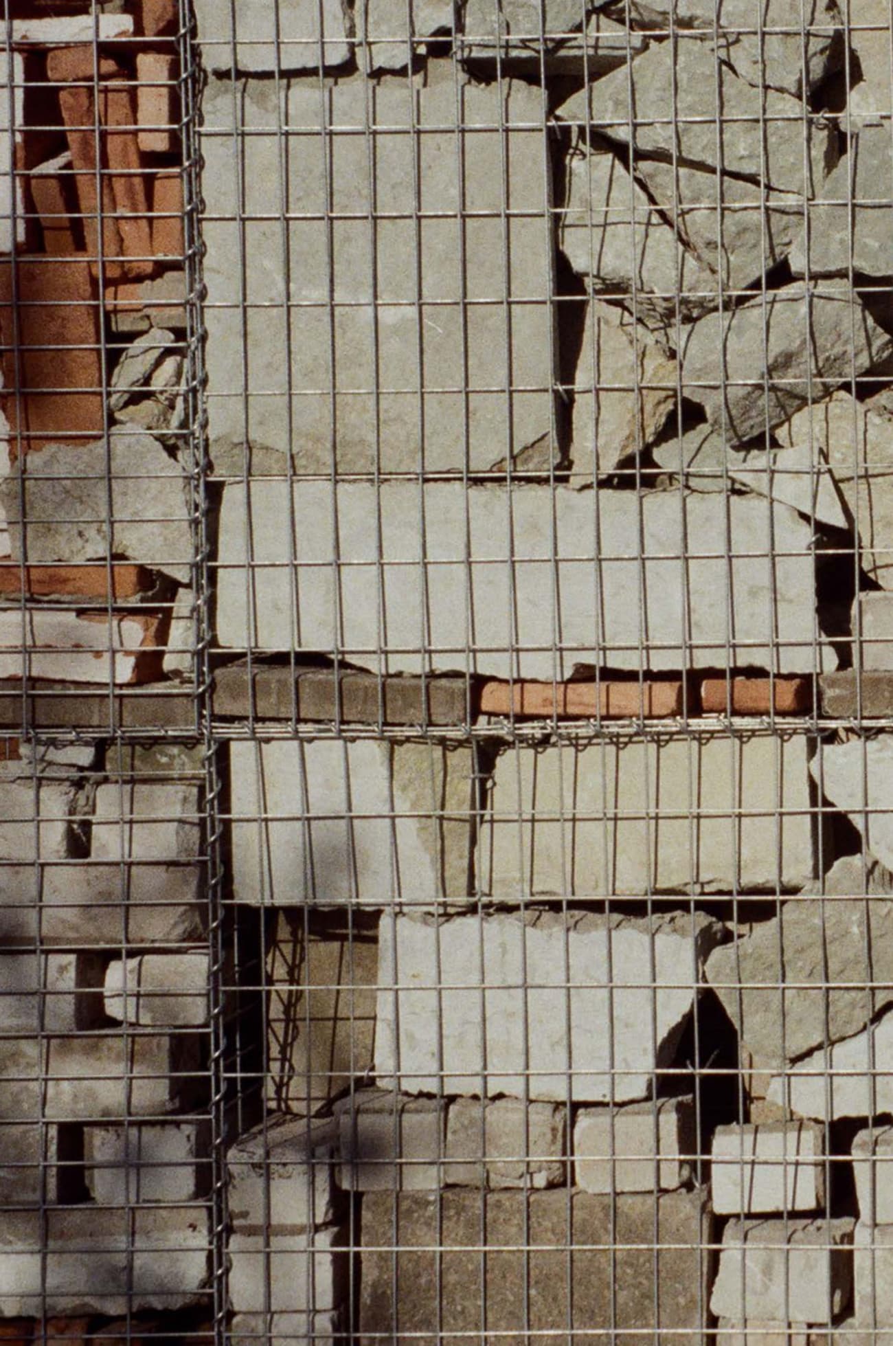 Architectural project - beige stone, natural stone, natural facade, stone cladding, light grey, upcycled materials, outdoor wall, stone finish, reclaimed stone, weathered stone, stone surface, gabion wall, recycled stone, mesh cage, wire mesh, rugged look, stone palette, construction element, gabion basket, architectural detail, raw materials, recycled materials, modular design, eco design, industrial aesthetic, urban landscape, sustainable architecture, industrial vibe, beige, brown, building facade, exterior wall, natural textures, minimalist design, circular construction, textured wall, rough texture, stonework, rustic style, earthy tones, stone wall, rustic wall, grey stone, sustainable facade, earthy colors
