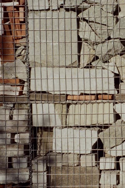 Architectural project - beige stone, natural stone, natural facade, stone cladding, light grey, upcycled materials, outdoor wall, stone finish, reclaimed stone, weathered stone, stone surface, gabion wall, recycled stone, mesh cage, wire mesh, rugged look, stone palette, construction element, gabion basket, architectural detail, raw materials, recycled materials, modular design, eco design, industrial aesthetic, urban landscape, sustainable architecture, industrial vibe, beige, brown, building facade, exterior wall, natural textures, minimalist design, circular construction, textured wall, rough texture, stonework, rustic style, earthy tones, stone wall, rustic wall, grey stone, sustainable facade, earthy colors