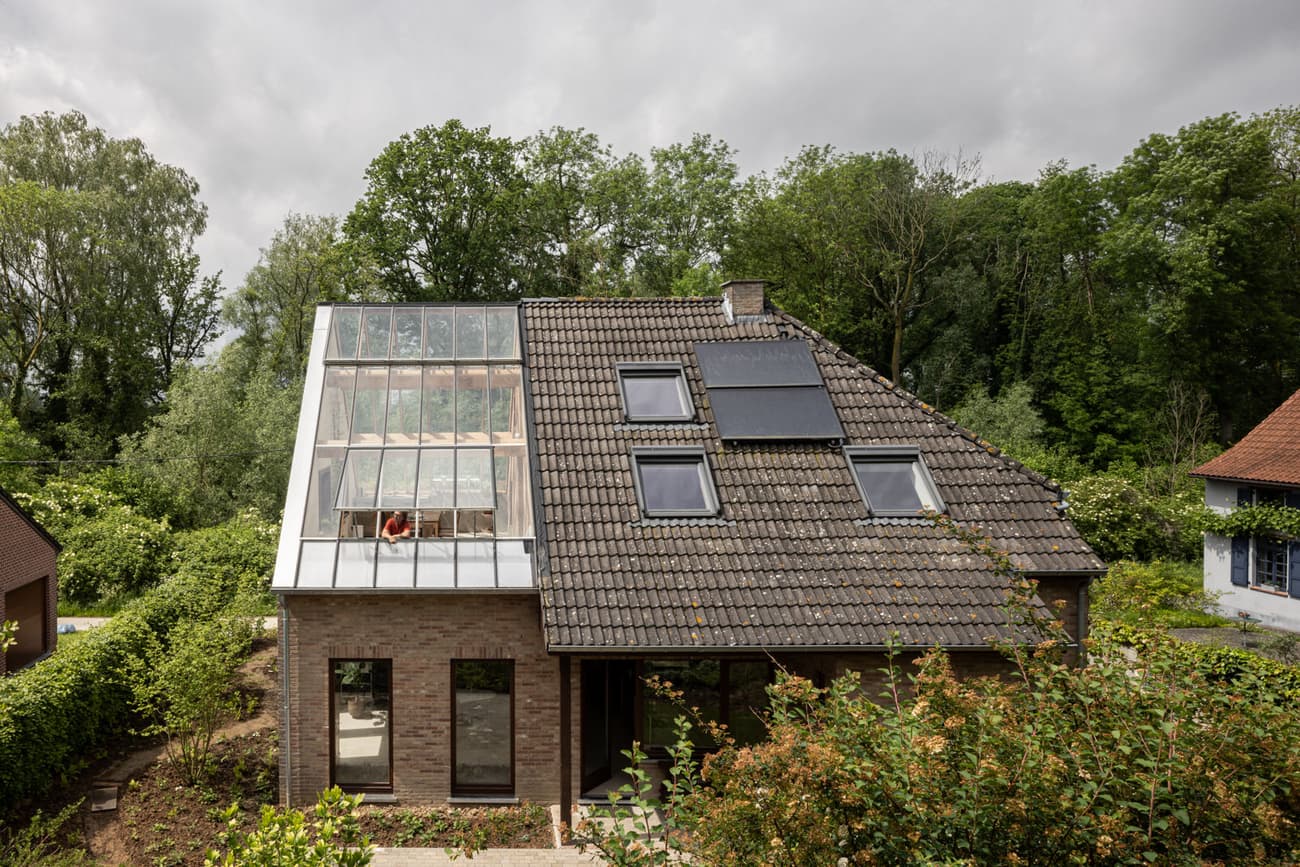 Architectural project - modern renovation, forest backdrop, garden house, skylights, tiled roof, home extension, glass roof, solar panels, attic conversion, eco upgrade, solar energy, sustainable retrofit, grey tiles, brown bricks, minimal design, wood, natural light, rustic touch, eco-conscious, sustainable design, glass, natural tones, green building, modern vibe, sustainable architecture, grey, green, brown, eco friendly, natural setting, green architecture, contemporary home, landscape integration, cozy vibe, outdoor view, energy efficient, rural living, brick, residential design, brick facade, eco house, countryside retreat, family home, passive solar, green surroundings, suburban home, daylighting, simple form, sustainable living, suburban house