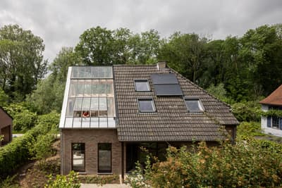 Architectural project - modern renovation, forest backdrop, garden house, skylights, tiled roof, home extension, glass roof, solar panels, attic conversion, eco upgrade, solar energy, sustainable retrofit, grey tiles, brown bricks, minimal design, wood, natural light, rustic touch, eco-conscious, sustainable design, glass, natural tones, green building, modern vibe, sustainable architecture, grey, green, brown, eco friendly, natural setting, green architecture, contemporary home, landscape integration, cozy vibe, outdoor view, energy efficient, rural living, brick, residential design, brick facade, eco house, countryside retreat, family home, passive solar, green surroundings, suburban home, daylighting, simple form, sustainable living, suburban house