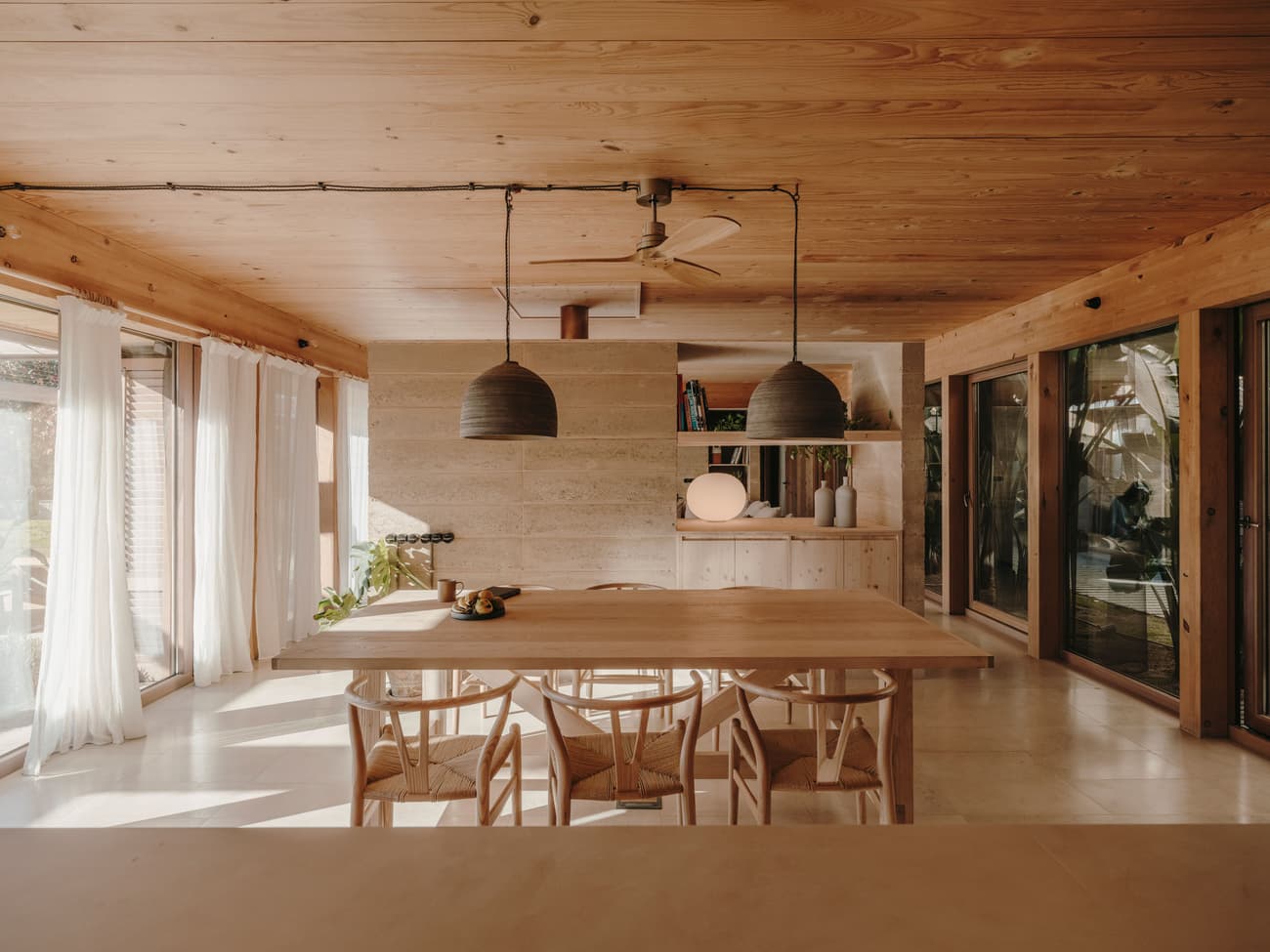 Architectural project - beige walls, family dining, home dining, wood table, minimalist chairs, simple chairs, casual decor, cozy interior, natural materials, wood, timber, natural light, rustic touch, glass, warm tones, neutral tones, daylight, wooden ceiling, beige, light wood, natural wood, eco friendly, honey wood, Scandinavian style, relaxed atmosphere, glass doors, timber walls, modern rustic, biophilic design, sustainable home, large windows, indoor outdoor, Nordic design, plaster, timber ceiling, warm ambiance, open layout, open plan, dining area, dining table, inviting space, sliding doors, plaster walls, earthy textures, comfortable living, indoor, bohemian vibe, living space, wooden walls