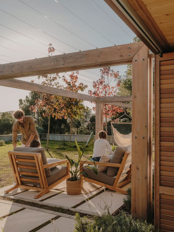 Architectural project - backyard lounge, cozy patio, modern patio, wooden pergola, timber pergola, garden chairs, hammock, garden pergola, timber posts, peaceful garden, residential outdoor, open air space, garden relaxation, garden furniture, leisure area, wood, timber, outdoor space, warm sunlight, natural light, outdoor living, sustainable design, natural tones, beige, brown, natural setting, retreat space, serene atmosphere, casual seating, relaxation spot, outdoor seating, earthy tones, eco friendly space, landscape design, lounge chairs, wooden structure, private garden, patio furniture, green space, laid-back vibe, family area