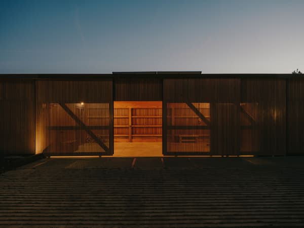 Architectural project - warm glow, ambient light, rural landscape, barn, modern barn, timber barn, slatted facade, evening ambiance, outdoor lighting, rural building, contemporary barn, farm building, agricultural building, barn renovation, barn conversion, evening glow, countryside aesthetic, evening setting, barn doors, large openings, exterior lighting, slats, natural materials, wood, timber, passive design, simple structure, sustainable architecture, beige, brown, timber facade, golden, low carbon design, functional design, modern design, architectural lighting, minimalist architecture, eco building, earth tones, natural palette, natural ventilation, open interior, open plan, peaceful vibe, tranquil atmosphere, serene setting, wooden facade, spacious interior, wooden cladding, rustic exterior, sleek design, warm lighting