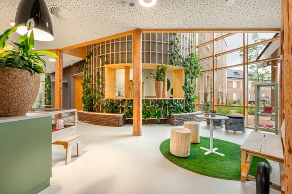 Architectural project - indoor greenery, airy interior, indoor garden, circular economy, circular seating, inviting center, community design, relaxed seating, multipurpose space, inclusive design, natural materials, wooden bench, relaxation zone, wood, timber, raw materials, natural light, passive design, natural tones, eco design, green, timber structure, daylight, beige, light wood, eco friendly, modern design, natural textures, casual seating, community hub, public space, gathering area, community center, social hub, sustainable building, biophilic design, white, wood accents, open layout, open plan, earthy tones, warm atmosphere, child friendly, playful vibe, bright space, educational space, welcoming space, skylight, indoor plants, wooden columns, play area, family-friendly, vertical garden, green wall