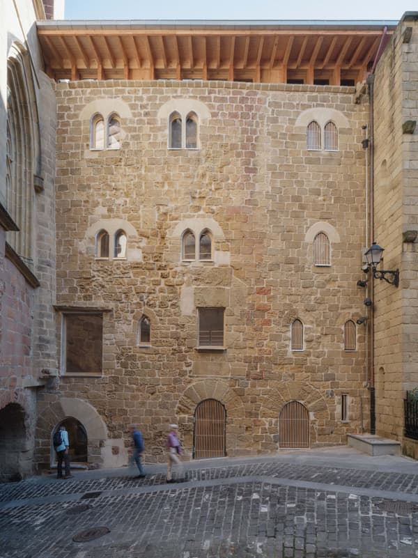 Architectural project - stone facade, stone masonry, vintage touch, historic building, cultural heritage, historic preservation, arched windows, historical vibe, heritage conservation, architectural heritage, heritage site, stone building, traditional facade, European architecture, castle-like, town center, wood, urban setting, warm tones, beige, brown, wooden beams, rustic charm, stone, stonework, sloped roof, traditional design, brick, brick facade, classic architecture, rustic exterior, public building, small windows, stone texture