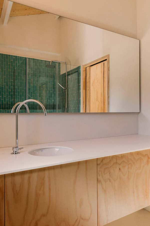 Architectural project - tile, minimal style, minimal bathroom, home bathroom, japandi vibe, private space, bathroom, large mirror, wall-mounted mirror, green tiles, vertical tiles, wooden cabinet, wood vanity, plywood cabinet, plywood finish, white countertop, chrome faucet, integrated sink, built-in sink, fresh atmosphere, tranquil bathroom, chrome, natural materials, wood, natural light, sustainable design, warm tones, eco design, contemporary style, green, daylight, plywood, spacious layout, beige, light wood, functional design, eco friendly, Scandinavian influence, simple design, natural textures, clean lines, light filled, white, cozy vibe, beige tones, compact design, airy space, inviting space, relaxing space, minimalist aesthetic, efficient layout, residential, sleek faucet, modern bathroom, ceramic, tiled wall